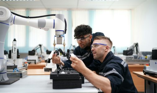 Industry 4.0: Young engineer works at a robotic arm