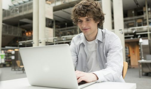 Student using laptop in a university library